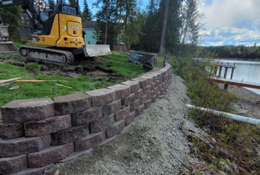 Reinforced retaining wall installation in a sloped backyard in Rathdrum