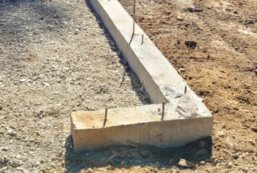 Excavator grading and leveling a shop pad site near Boekel Rd in Rathdrum