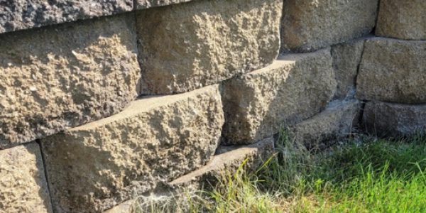 Low-height block garden wall installed near Hayden Meadows Elementary to define flower beds and prevent minor slope runoff while enhancing yard value and appearance.